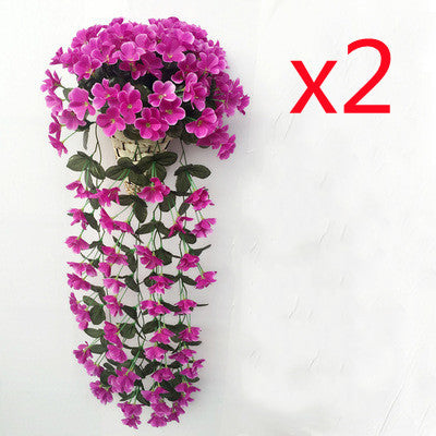 Violette Ranken hängen von künstlichen Blumen am Fensterbalkon.