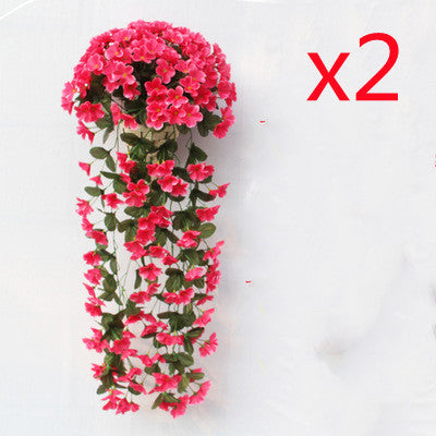 Violette Ranken hängen von künstlichen Blumen am Fensterbalkon.