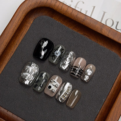 Handgefertigte Maniküre mit Goldpuder für den Nagellack im Heavy-Industrial-Stil