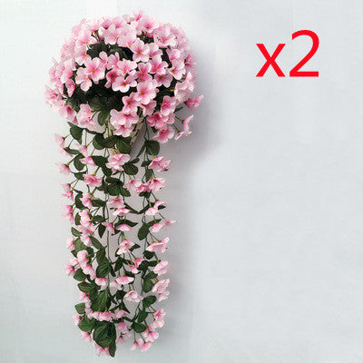 Violette Ranken hängen von künstlichen Blumen am Fensterbalkon.