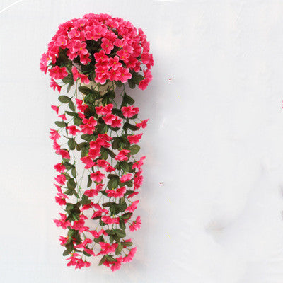 Violette Ranken hängen von künstlichen Blumen am Fensterbalkon.